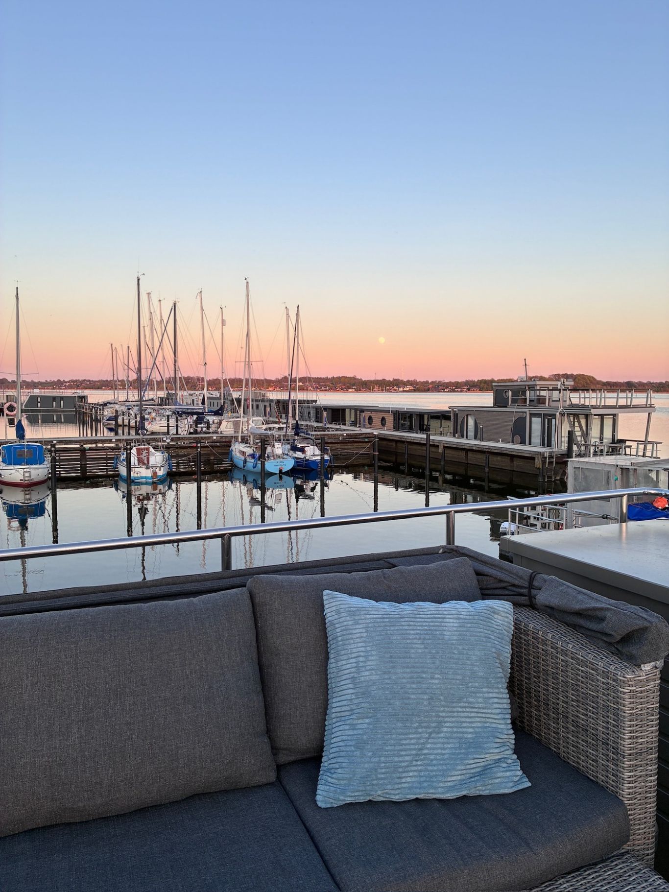 Abendstimmung im Hafen. Blick von der Lounge auf die Segelboote im Hafen und den gefärbten Himmel.